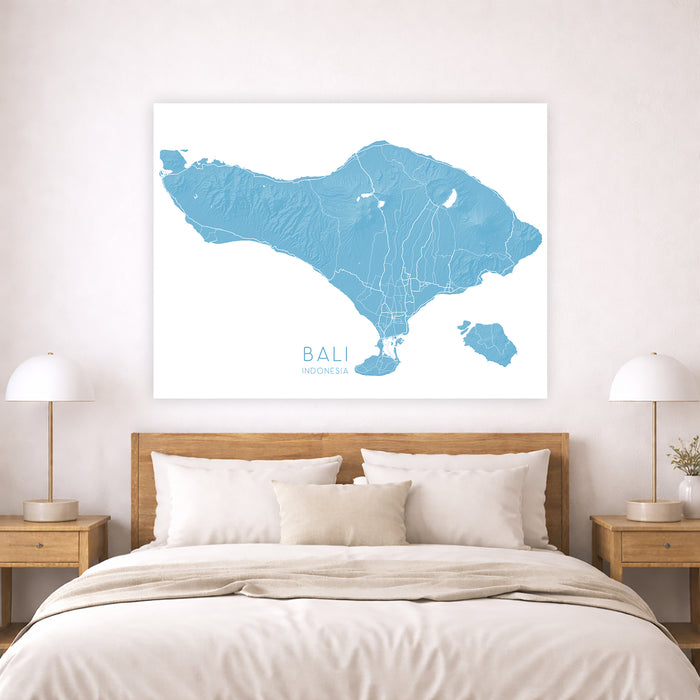 Map of Bali on a wall above a bed with wooden headboard and nightstands.