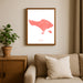 Framed map of Bali on a wall above a sofa with a plant beside it.