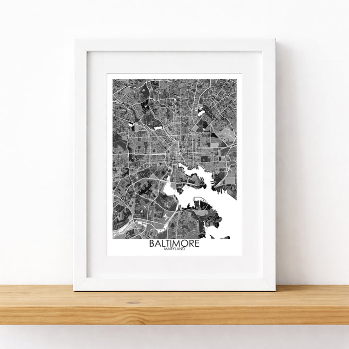 Framed black and white map of Baltimore on a wooden surface with a white background