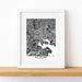 Framed black and white map of Baltimore on a wooden surface with a white background