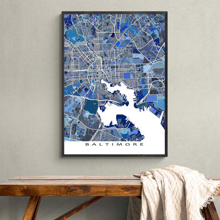 Framed map of Baltimore on a wall above a wooden bench.