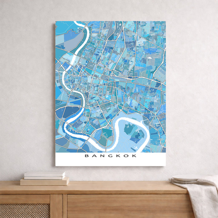 Map of Bangkok in blue tones on a white wall above a wooden shelf.