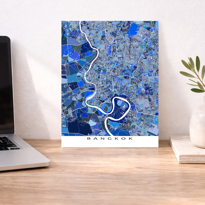 Map of Bangkok on a wall above a desk with a laptop and plant.