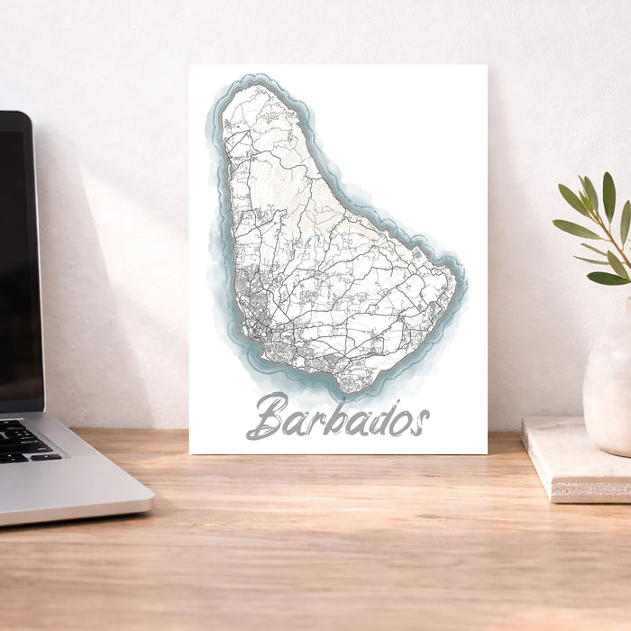 Map of Barbados on a desk with a laptop and plant