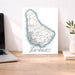 Map of Barbados on a desk with a laptop and plant