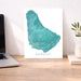 Map of Barbados on a desk with a laptop and plant