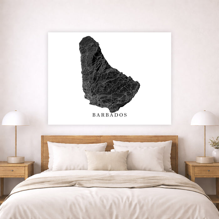 Framed map of Barbados above a bed in a bedroom setting