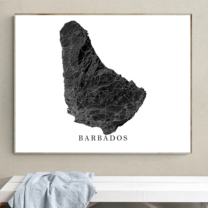 Framed map of Barbados on a wall above a white bench.