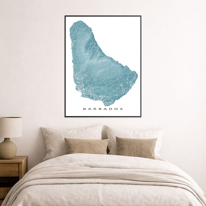 Framed map of Barbados on a wall above a bed in a bedroom.