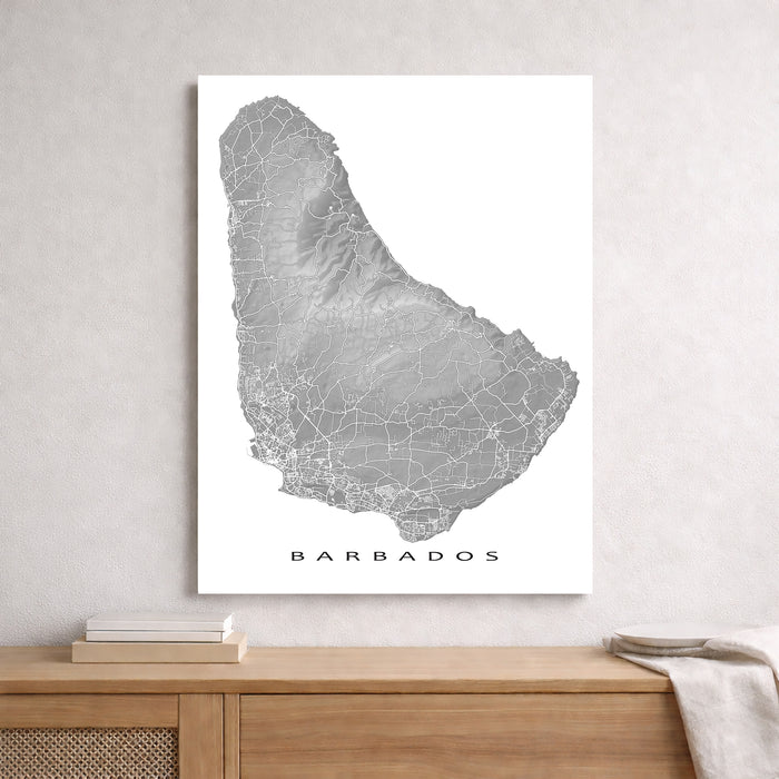 Map of Barbados on a white wall above a wooden shelf.