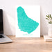 Map of Barbados on a desk with a laptop and plant