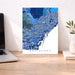Map of Barcelona on a wall above a desk with a laptop and plant.