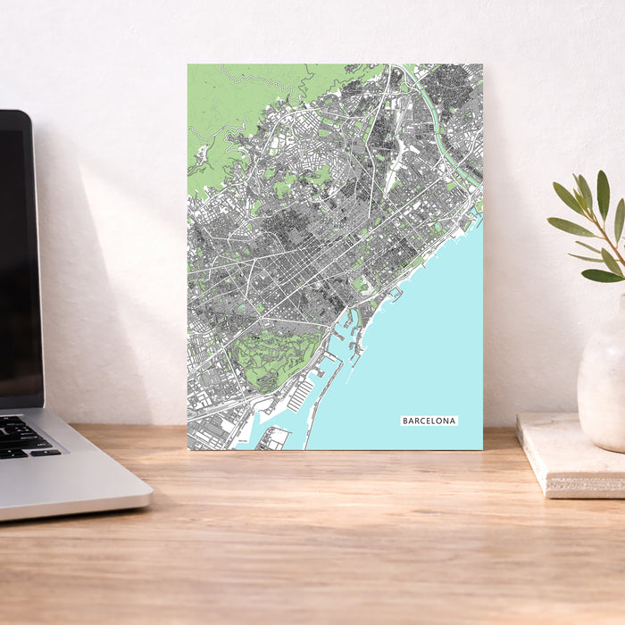 Map of Barcelona on a desk with a laptop and plant