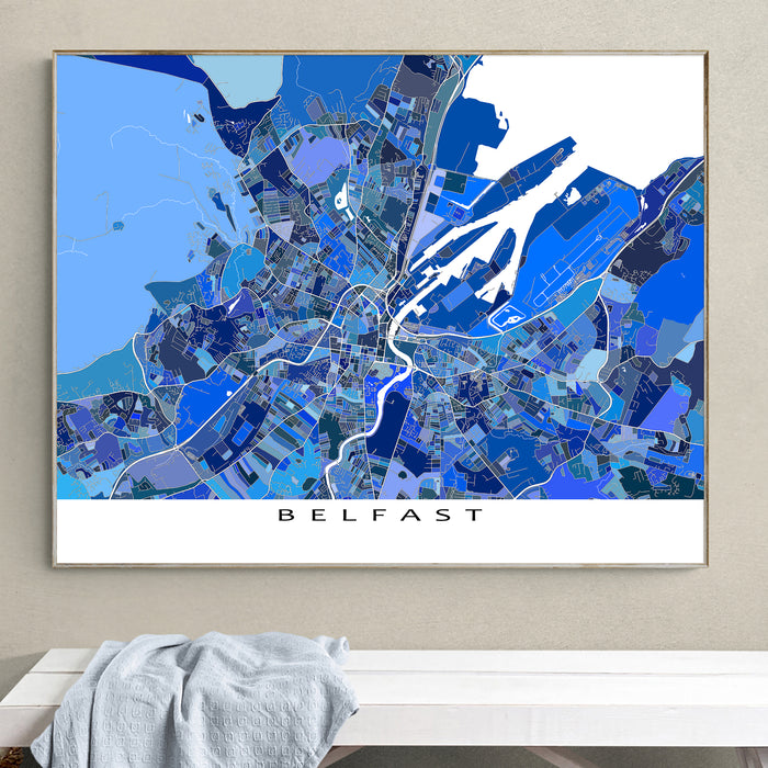 Framed map of Belfast on a wall above a white bench.