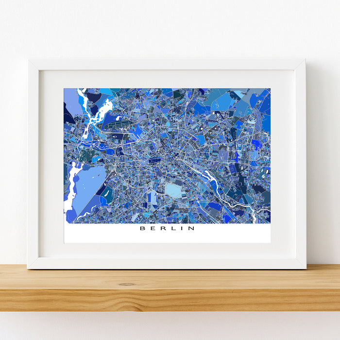 Framed map of Berlin with a blue color scheme on a white wall.