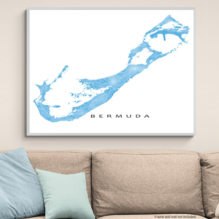 Map of Bermuda framed on a wall above a beige sofa with light blue pillows.