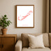 Framed map of Bermuda on a wall above a sofa with a plant beside it.
