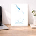 Map of Berry Islands on a desk with a laptop and plant