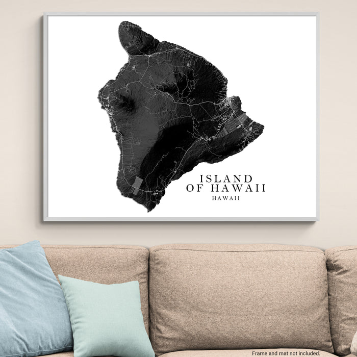 Framed map of the Island of Hawaii on a wall above a beige sofa with light blue pillows.