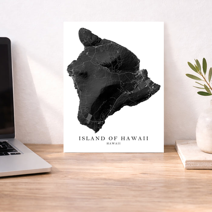 Map of the Island of Hawaii on a desk with a laptop and plant.