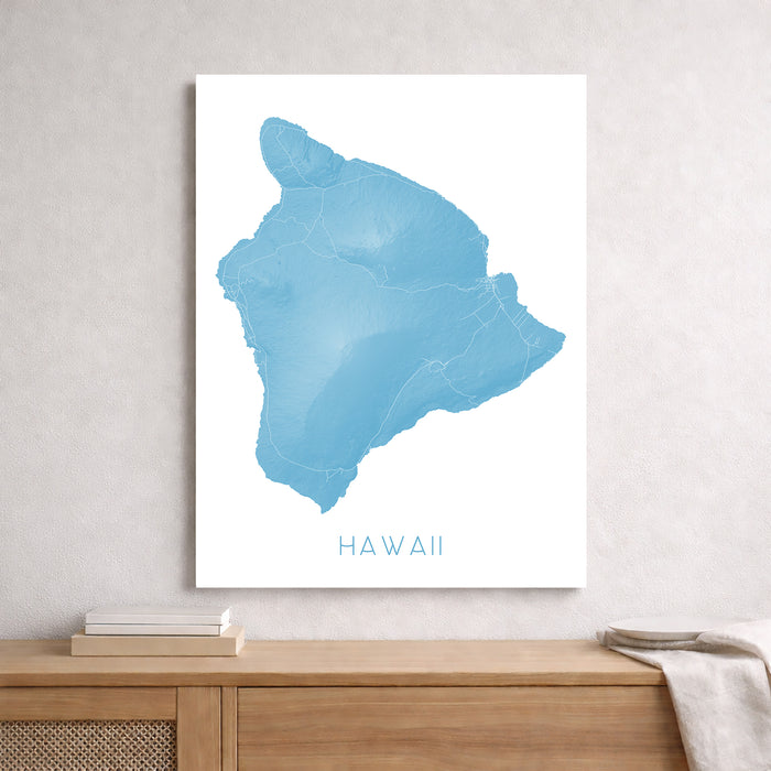 Map of Hawaii in blue on a white background, framed and leaning against a wall.
