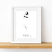A framed black and white art print featuring a minimalist sketch of a butterfly and the text 'BIMINI THE BARAHAM' at the bottom, displayed on a light wood shelf against a white wall.