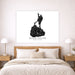 A black and white canvas print of Block Island, Rhode Island, styled on a light beige wall above a wooden bed with white and beige linens in a modern bedroom setting.