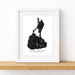 A framed black and white map art print of Block Island, Rhode Island, displayed on a light wood shelf against a white wall.