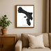 Framed map of Bonaire on a wall above a sofa with a plant beside it.