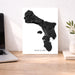 Map of Bonaire on a white background displayed on a wooden desk with a laptop and plant.