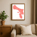 Framed map of Bonaire on a wall above a sofa with a plant beside it.