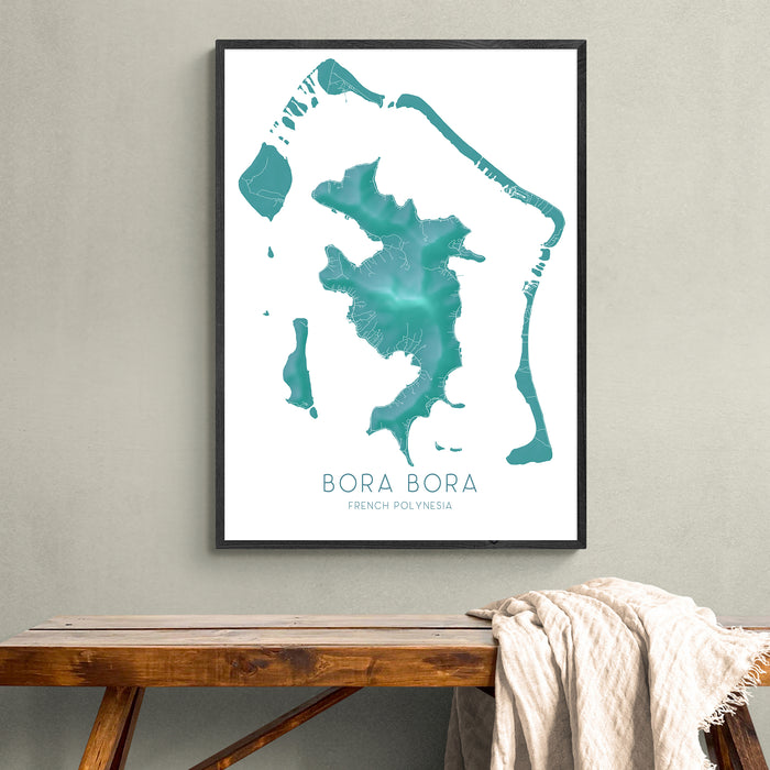 Framed map of Bora Bora on a wall above a wooden bench.