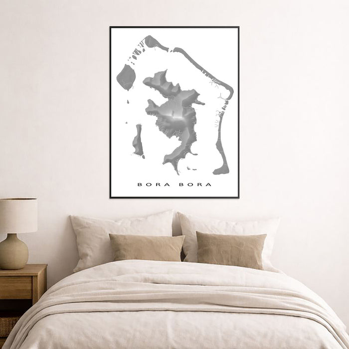 Framed map of Bora Bora on a wall above a bed in a bedroom.