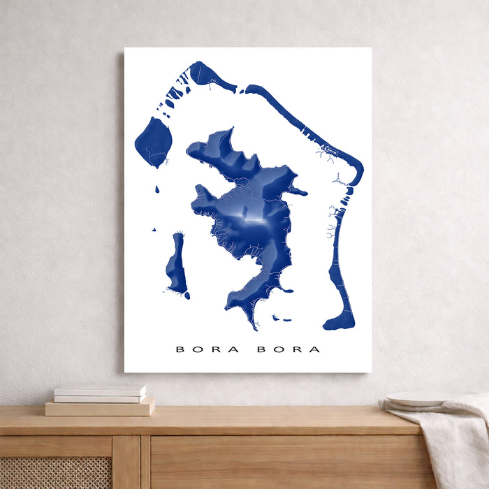 Map of Bora Bora in blue on a white background, displayed on a wall above a wooden shelf.