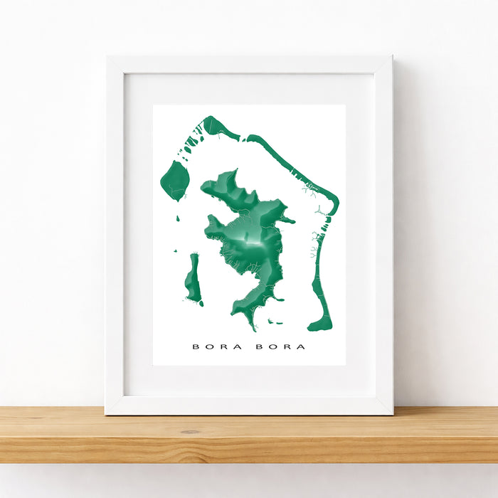 Framed map of Bora Bora with a white border on a wooden surface.