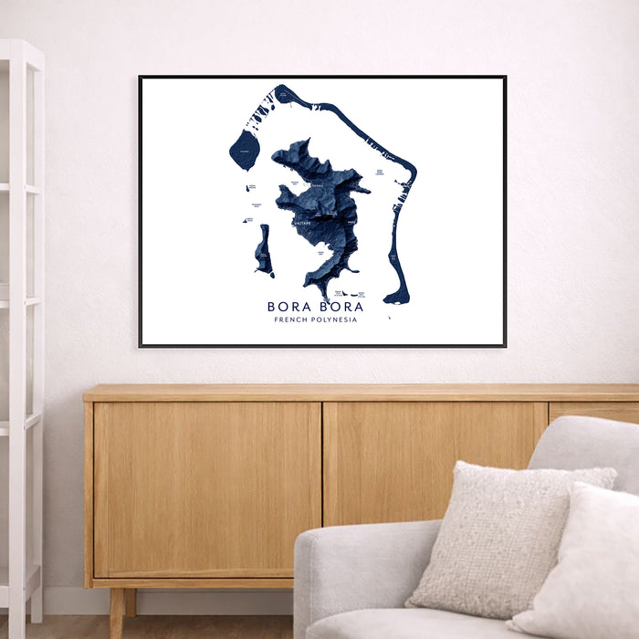 Framed map of Bora Bora on a wall above a wooden cabinet and sofa.