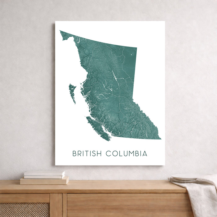 Map of British Columbia on a white wall above a wooden shelf.