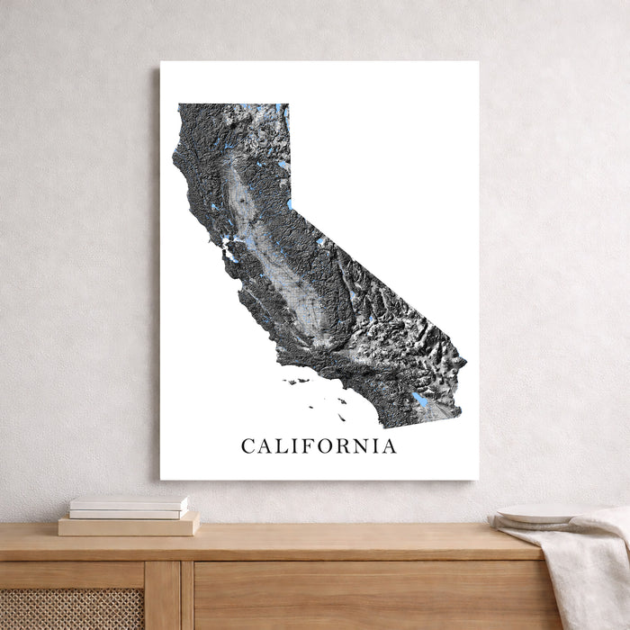 Map of California on a white wall above a wooden shelf.