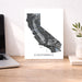 Map of California on a desk with a laptop and plant