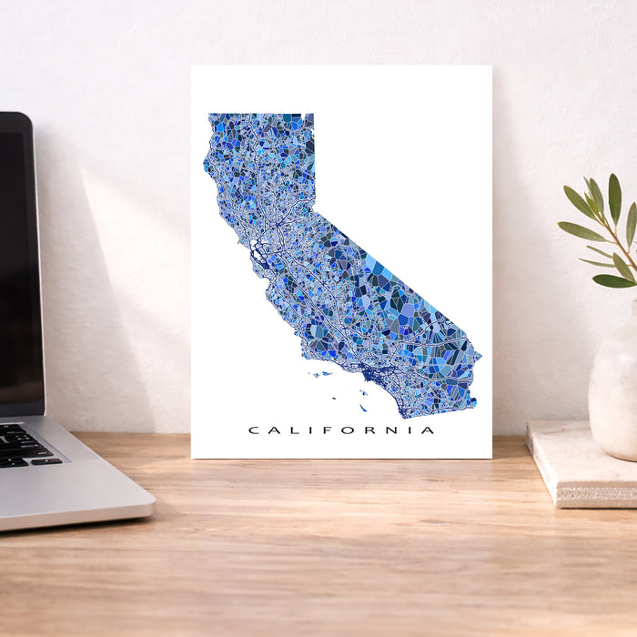 Map of California on a desk with a laptop and plant