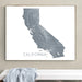 Framed map of California on a wall above a white bench.