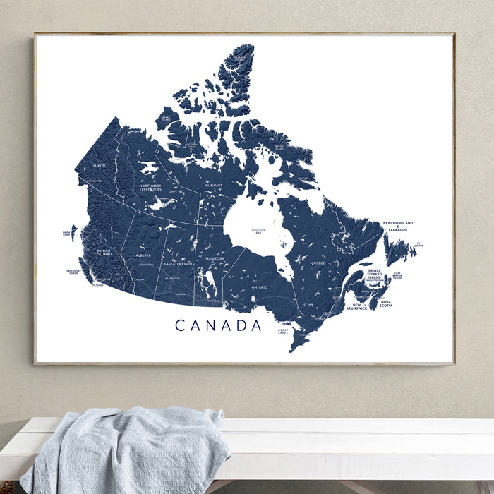 Framed map of Canada on a wall above a white surface.