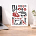 Decorative print with nature-themed illustrations on a desk next to a laptop.