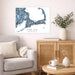 Living room with a map of Cape Cod on the wall, a couch, and a side table with a vase and books.