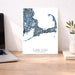 Cape Cod Massachusetts map print on a desk with a laptop and plant.