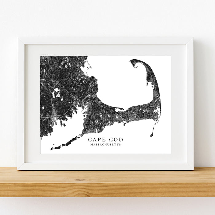 Framed black and white map of Cape Cod, Massachusetts on a wooden shelf.