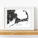 Framed black and white map of Cape Cod, Massachusetts on a wooden shelf.