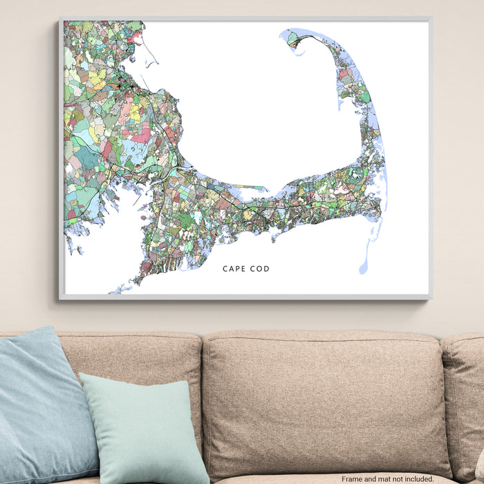 Framed map of Cape Cod above a beige sofa with blue pillows.