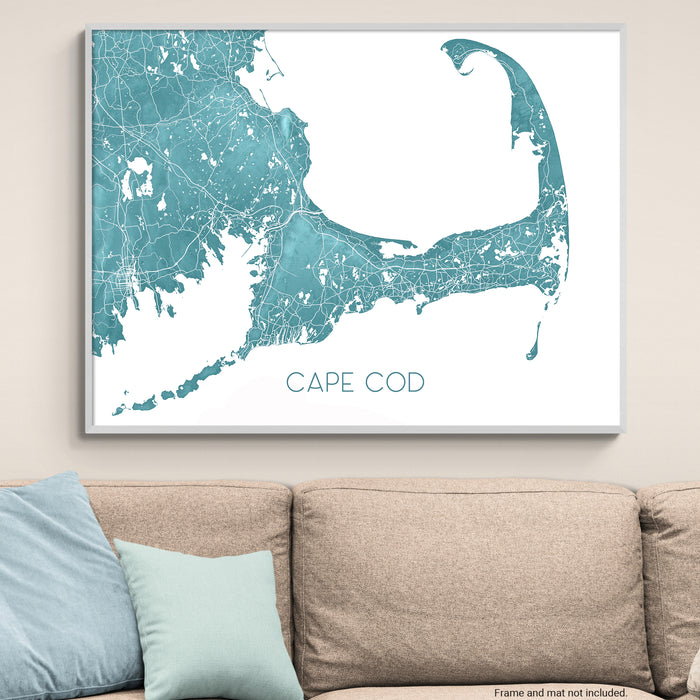 Framed map of Cape Cod on a wall above a beige sofa with light blue pillows.