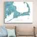 Framed map of Cape Cod on a wall above a beige sofa with light blue pillows.